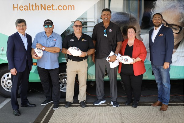 Community partners standing in front of a Health Net mobile clinic during a vaccine awareness event.